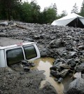 An official of Forest Home Christian Conference Center in Forest Falls, Calif., inspects damage on the property following thunderstorms on Sunday, Aug. 3, 2014. About 1,500 residents of Oak Glen, and another 1,000 residents of Forest Falls in the San Bernardino Mountains were unable to get out because the roads were covered with mud, rock and debris, authorities said. (AP Photo/The Press-Enterprise, David Bauman)