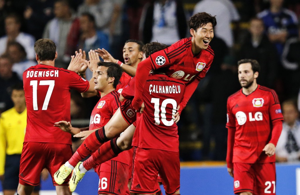 Bayer 04 Leverkusen's Heung-Min Son of South Korea is lifted by teammate Hakan Calhanoglu after Son scored the his teams third goal against FC Copenhagen during the Champions League play-offs first leg soccer match at Parken Stadium, Copenhagen, Denmark, Tuesday, Aug. 19, 2014. (AP Photo/Polfoto, Jens Dresling)