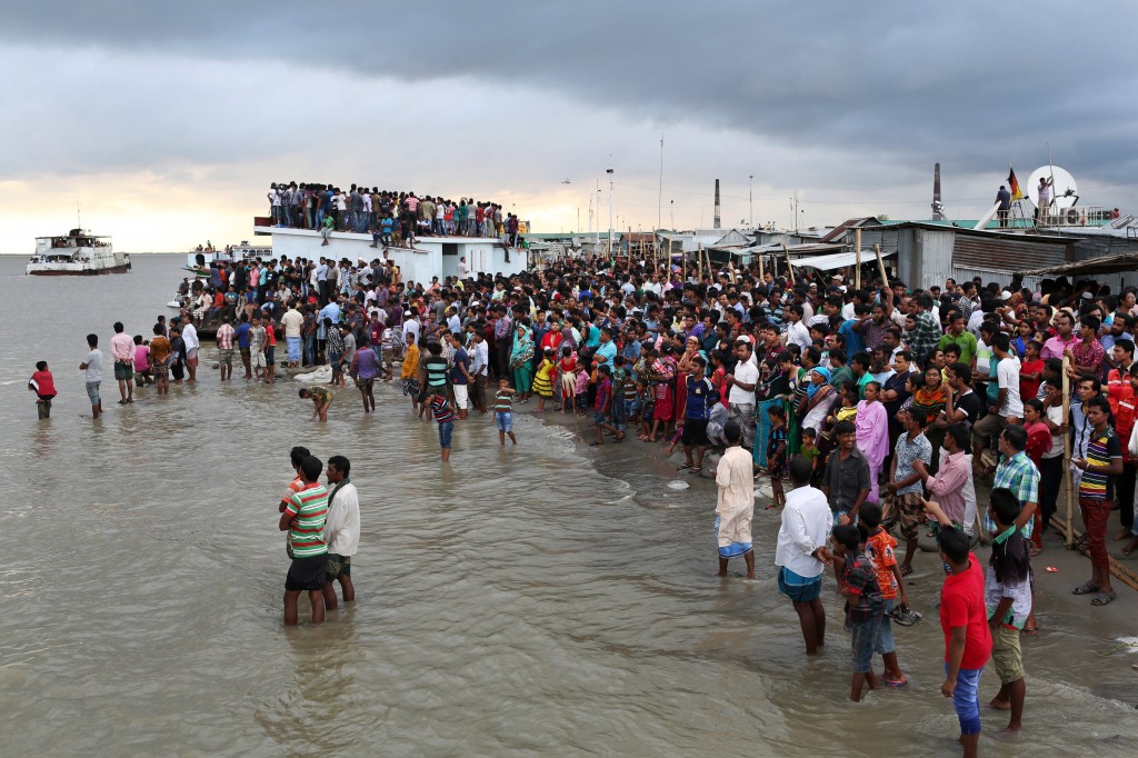 Bangladeshi people gather on the banks of  the River Padma after a passenger ferry capsized in Munshiganj district, Bangladesh, Monday, Aug. 4, 2014. A passenger ferry carrying hundreds of people capsized Monday in central Bangladesh, and at least 44 people either swam to safety or were rescued but the number of missing passengers is not yet known. (AP Photo/ A.M. Ahad)