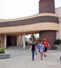 People walk past South Pasadena, Calif., High School Tuesday, Aug. 19, 2014, after authorities announced the arrest of two high school students suspected of planning a massacre at the school after investigators monitored their Internet activities. South Pasadena police chief Arthur Miller said that school officials had heard about the plot and informed police, who determined the threat was credible. Police say the boys, ages 16 and 17, didn't have weapons but were researching automatic weapons and explosives, especially propane. (AP Photo/Nick Ut)