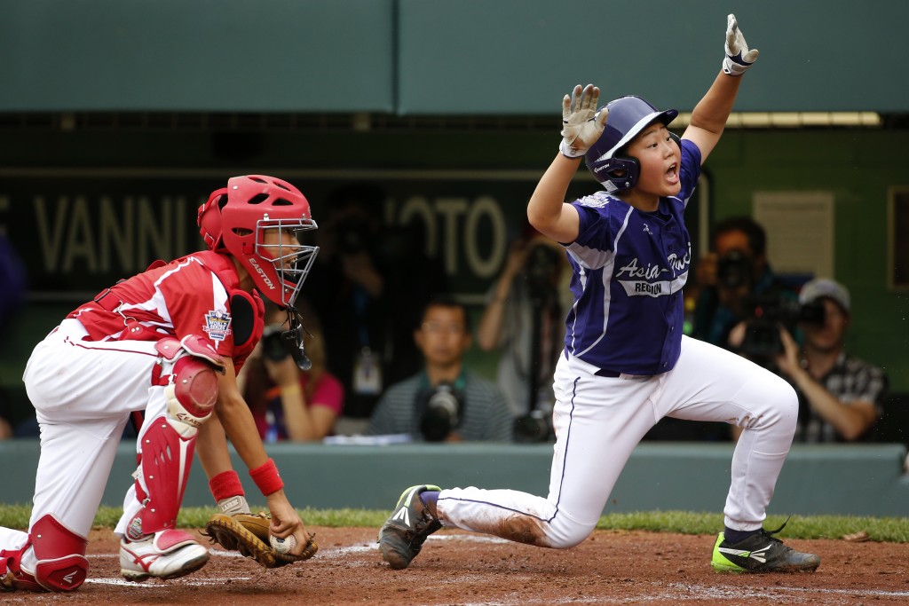 Japan catcher Shingo Tomita, left,  misses the tag as South Korea's Jin Woo Jeon scores on a single by Ji Ho Park in the second inning of an International Championship baseball game at the Little League World Series tournament in South Williamsport, Pa., Saturday Aug. 23, 2014. (AP Photo/Gene J. Puskar)