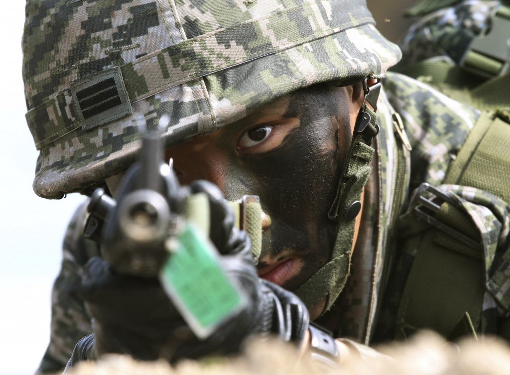 A South Korean marine aims his machine gun during the U.S.-South Korea joint landing exercises called Ssangyong as part of the Foal Eagle military exercises in Pohang, South Korea, Monday, March 31, 2014.  South Korea says North Korea has announced plans to conduct live-fire drills near the rivals' disputed western sea boundary.(AP Photo/Ahn Young-joon)