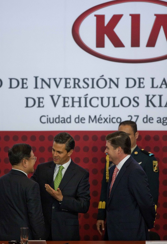 Mexico's President Enrique Pena Nieto, center, talks with KIA Vice Chairman and CEO Hyoung-Keun Lee, left, and the Gov. of Nuevo Leon, Rodrigo Medina, right, during an announcement regarding a new KIA Auto assembly plant to be set up in Mexico, Wednesday, Aug. 27, 2014. KIA announced the construction of a new auto plant in the northern state of Nuevo Leon which is slated to start operating in 2016. (AP Photo/Eduardo Verdugo)