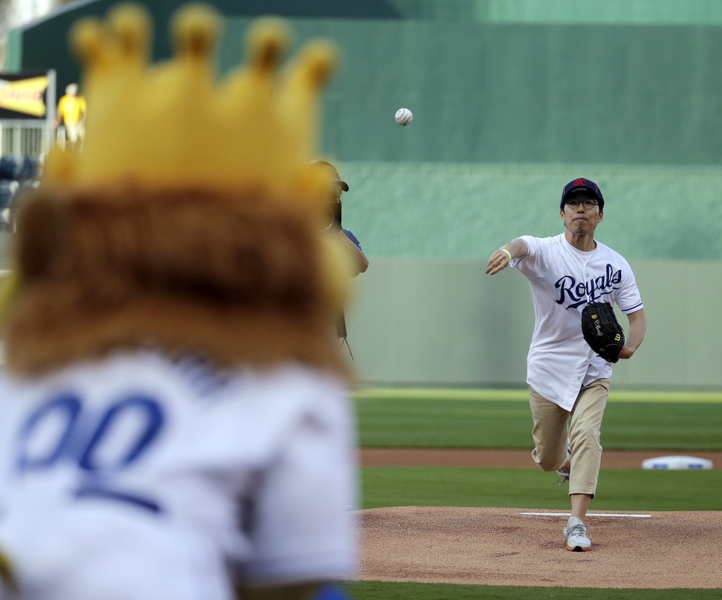 Longtime Kansas City Royals fan Sung Woo Lee, from South Korea, throws the ceremonial first pitch before a baseball game against the Oakland Athletics, Monday, Aug. 11, 2014, in Kansas City, Mo. (AP Photo/Charlie Riedel)