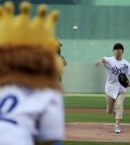 Longtime Kansas City Royals fan Sung Woo Lee, from South Korea, throws the ceremonial first pitch before a baseball game against the Oakland Athletics, Monday, Aug. 11, 2014, in Kansas City, Mo. (AP Photo/Charlie Riedel)