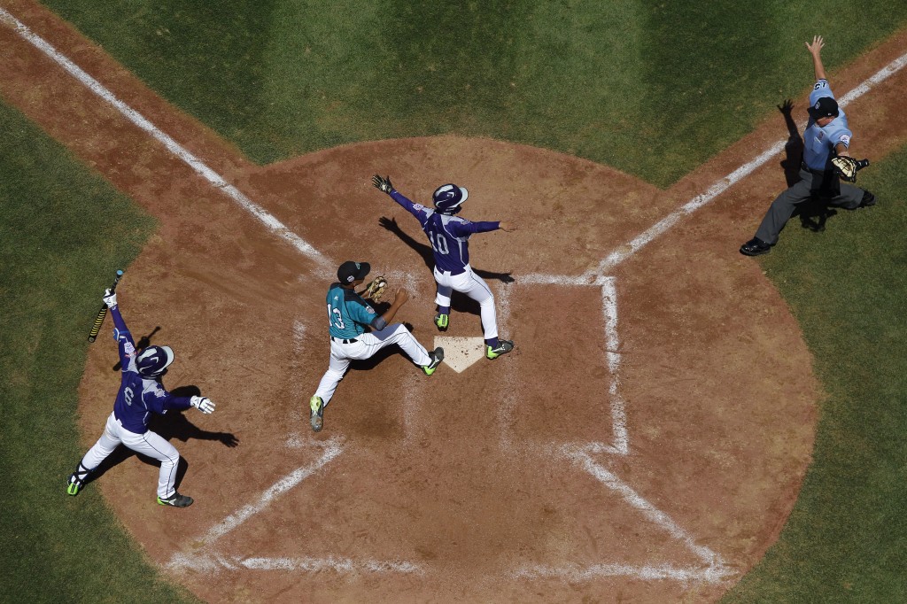 South Koreas Ji Ho Park (10), Dong Hwan Ahn (6) and Puerto Ricos Emanuel Alicea (13) react to a safe call from home plate umpire Garry Smith after Park scored on a wild pitch during the sixth inning of an International double elimination baseball game at the Little League World Series, Sunday, Aug. 17, 2014, in South Williamsport, Pa. South Korea won 8-5. (AP Photo/Matt Slocum)