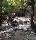 A car is lodged in the debris on Monday, Aug. 4, 2014, where a body was found Sunday that was swept into the rain-swollen water course in Mount Baldy, Calif. About 2,500 people were stranded early Monday after thunderstorms caused mountain mudslides in Southern California. (AP Photo/Brian Melley)