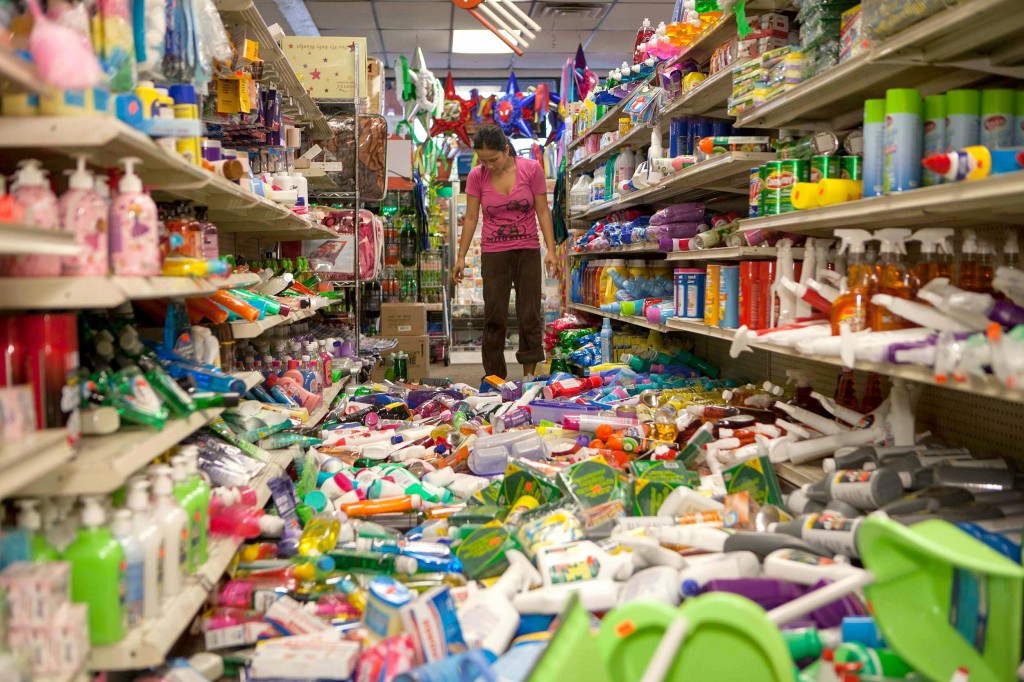 Nina Quidit cleans up the Dollar Plus and Party Supplies Store in American Canyon Calif. after an earthquake on Sunday Aug. 24, 2014. Quidit and her husband were woken up in the early morning hours by the store's alarm company and immediately drove in to begin clean up. The 6.0-magnitude quake caused six significant fires, including at four mobile homes, Napa Division Fire Chief Darren Drake said. (AP Photo/Alex Washburn)