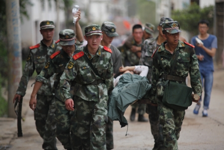 In this photo released by China's Xinhua News Agency, rescuers transport injured people after an earthquake in Zhaotong City in the densely populated Ludian county in southwest China's Yunnan Province, Sunday Aug. 3, 2014. The strong earthquake in southern China's Yunnan province toppled thousands of homes on Sunday, killing at least 175 people and injuring more than 1,400, according to China's official Xinhua News Agency. (AP Photo / Xinhua, Zhang Guangyu)