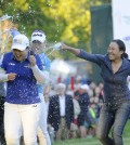 Jenny Shin, left, Meena Lee, center, and Illhee Lee, right, spray Champion Inbee Park after she won the Wegmans LPGA golf championship in Pittsford, N.Y., Sunday, Aug. 17, 2014. Park won in a sudden death playoff round. (AP Photo/Gary Wiepert)