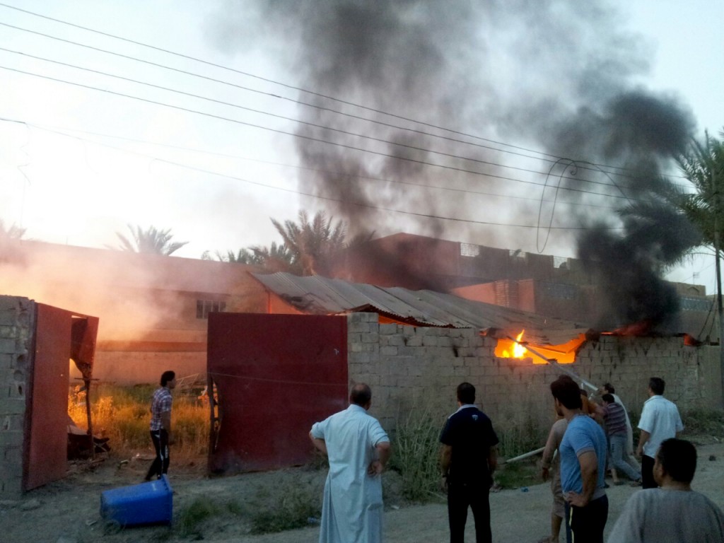 Civilians inspect a burned house after a bombing in Fallujah, 40 miles (65 kilometers) west of Baghdad, Iraq, Monday, Sept. 15, 2014. (AP Photo)