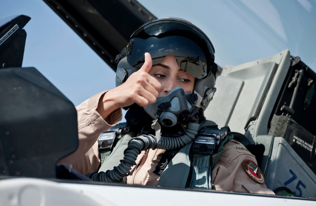 This June 13, 2013 photo provided by the Emirates News Agency, WAM, shows Mariam al-Mansouri, the first Emirati female fighter jet pilot gives the thumbs up as she sits in the cockpit of an aircraft, in United Arab Emirates. A senior United Arab Emirates diplomat says the Gulf federation’s first female air force pilot helped carry out airstrikes against Islamic State militants earlier this week. The Emirati embassy in Washington said on its official Twitter feed Thursday, Sept. 25, 2014 that Ambassador Yousef al-Otaiba confirmed the F-16 pilot’s role. Rumors had swirled on social media that Maj. Mariam al-Mansouri was involved in the strikes, but Emirati officials had not previously confirmed that was the case.(AP Photo/Emirates News Agency, WAM) 