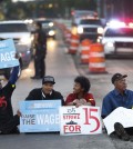 Protesters block traffic on Mack Avenue in Detroit as part of a national protest to push fast-food chains to pay their employees at least $15 an hour Thursday, Sept. 4, 2014. Hundreds of workers from McDonald's, Taco Bell, Wendy's and other fast-food chains are expected to walk off their jobs Thursday, according to labor organizers of the latest national protest to push the companies to pay their employees at least $15 an hour. (AP Photo/Paul Sancya)