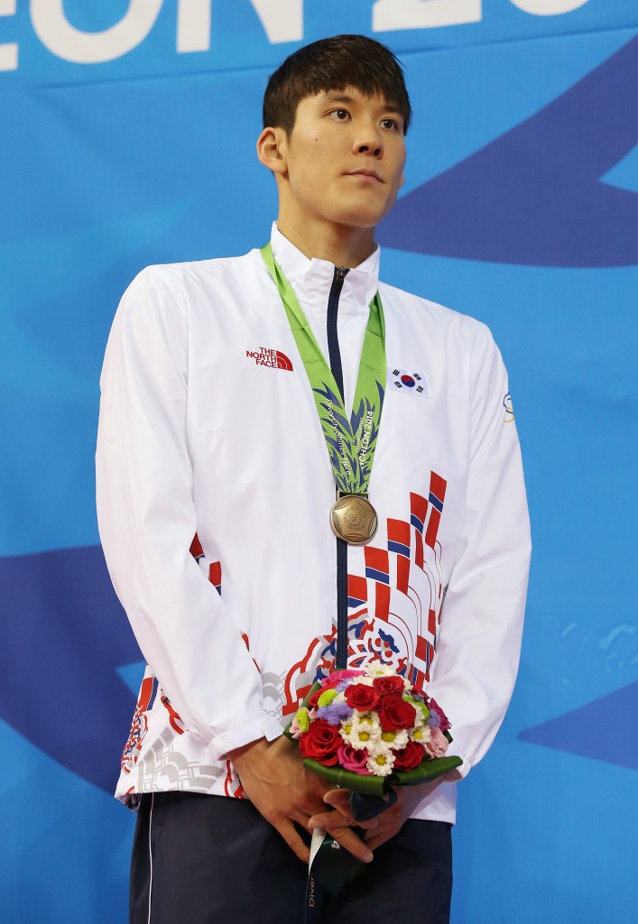 South Korea's Park Tae-hwan stands on the podium with his bronze medal following the men's 400-meter freestyle relay final at the 17th Asian Games in Incheon, South Korea, Tuesday, Sept. 23, 2014.(AP Photo/Rob Griffith)