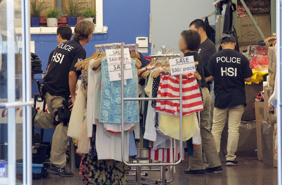 Law enforcement agents check a clothing store during a raid in the Los Angeles Fashion District Wednesday, Sept. 10, 2014. U.S. agents raided dozens of businesses in the fashion district of Los Angeles early Wednesday as part of an investigation into suspected money laundering done for Mexican drug cartels. (AP Photo/ Nick Ut )