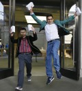 The first people in the queue, Sam Sheikh, left, and Jameel Ahmed, right, celebrate for the media after buying the new iPhone6, outside the Apple shop in London, Friday, Sept. 19, 2014. The new Apple iPhone6 went on sale at the shop on Friday. (AP Photo/Kirsty Wigglesworth)