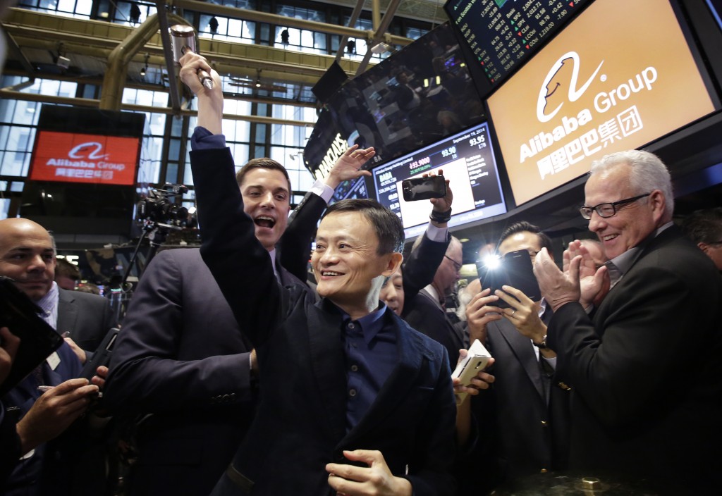 Jack Ma, center, founder of Alibaba, raises a ceremonial mallet before striking a bell during the company's IPO at the New York Stock Exchange, Friday, Sept. 19, 2014 in New York. The stock is to start trading Friday under the ticker "BABA." (AP Photo/Mark Lennihan)