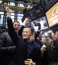 Jack Ma, center, founder of Alibaba, raises a ceremonial mallet before striking a bell during the company's IPO at the New York Stock Exchange, Friday, Sept. 19, 2014 in New York. The stock is to start trading Friday under the ticker "BABA." (AP Photo/Mark Lennihan)