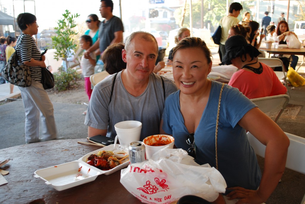 Marc Girsky, left, and his wife, Kim Hae-jung, enjoy food from vendors at the 41st Los Angeles Korean Festival on Saturday. (Brian Han/The Korea Times)