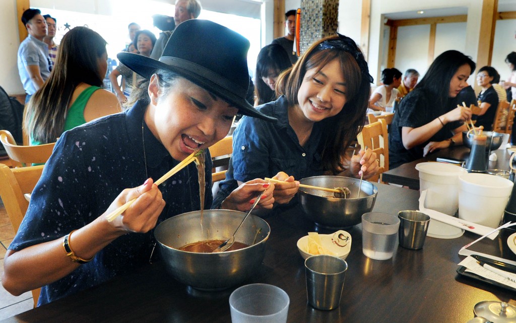 A customer at a Koreatown restaurant enjoys an ice-filled bowl of cold nengmyun. (Park Sang-hyuk/The Korea Times)