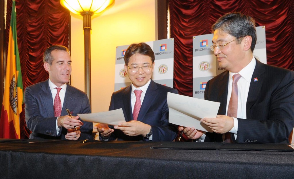 Los Angeles Mayor Eric Garcetti, left, signs an MOU at a trade symposium at city hall Wednesday, joined by Korean Consul General Kim Hyun-myung, center, and BBCN Bank President and CEO Kevin Kim.