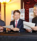 Los Angeles Mayor Eric Garcetti, left, signs an MOU at a trade symposium at city hall Wednesday, joined by Korean Consul General Kim Hyun-myung, center, and BBCN Bank President and CEO Kevin Kim.