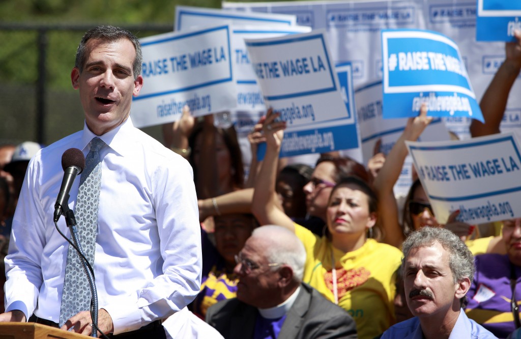 Los Angeles Mayor Eric Garcetti makes an announcement at the Martin Luther King, Jr. Park in South Los Angeles with a coalition of business, labor, community, and faith leaders from across the city on Monday, Sept. 1, 2014. Garcetti announced his proposal to raise the minimum wage in Los Angeles from the current $9 per hour to $13.25 in 2017. (AP Photo/Richard Vogel)