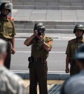 A North Korean soldier takes picture of an American soldier and a Korean military police officer at Panmujeom. (Newsis)