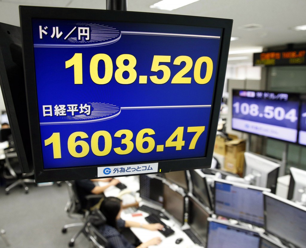 Japan Financial Markets Money traders of a foreign exchange dealing company work under an electric screen indicating the U.S. dollar against the Japanese yen in Tokyo Thursday, Sept. 18, 2014. The U.S. dollar hit its highest level against yen in six years. (AP Photo/Kyodo News)