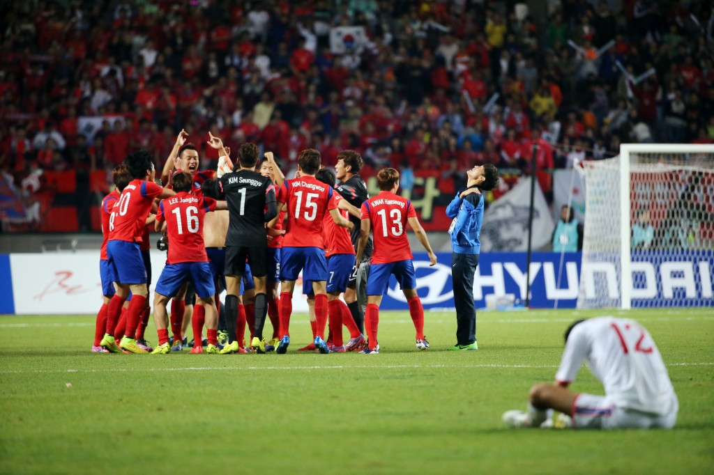 South Korean players celebrate while a North Korean player cannot hide his disappointment. (Yonhap)