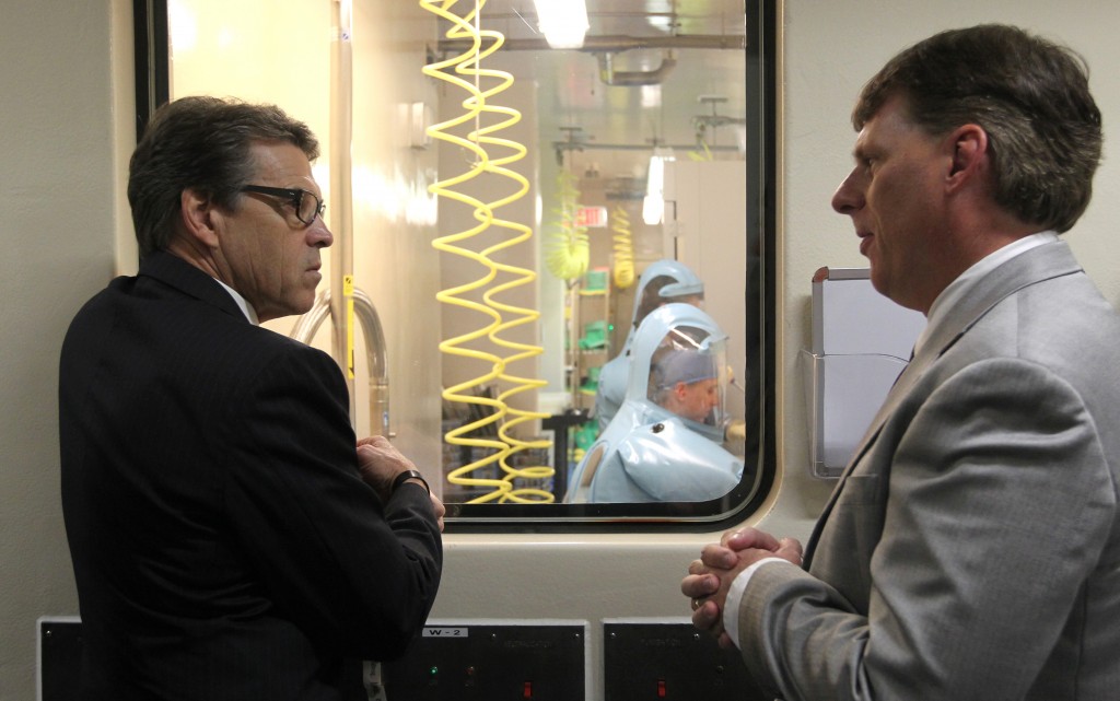 Tom Geisbert, right, a professor of Microbiology and Immunology at the University of Texas Medical Branch, explains to Texas Gov. Rick Perry the work researchers are conducting in a Bio Safety Level 4 lab in the Galveston National Laboratory on Tuesday, Oct. 7, 2014. Perry and other state officials toured the national laboratory a day after he created a Task Force on Infectious Disease Preparedness and Response. (AP Photo/The Daily News, Jennifer Reynolds, Pool)