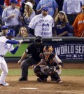 In this Wednesday, Oct. 22, 2014, photo, Miami Marlins fan Laurence Leavy, rear right, is shown wearing a bright orange Marlins jersey during Game 2 of baseball's World Series in Kansas City, Mo. Leavy's orange Marlins jersey made him easy to spot amid a sea of Kansas City Royals blue. He said a Royals official approached him offering to move him to the team owner's suite, but Leavy declined. (AP Photo/Charlie Riedel)