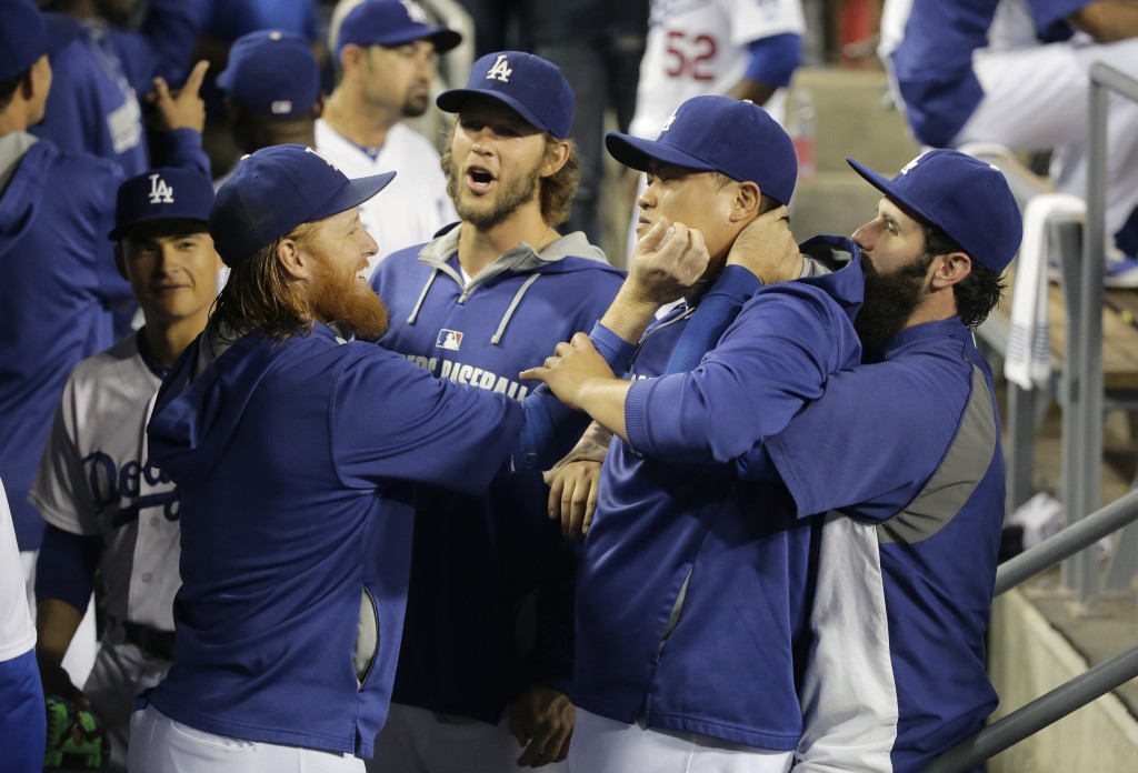 Los Angeles Dodgers' Justin Turner, from left, pitcher Clayton Kershaw, pitcher Hyun-Jin Ryu, of South Korea, and Scott Van Slyke joke around in the dugout before a baseball game against the San Francisco Giants Monday, Sept. 22, 2014, in Los Angeles. (AP Photo/Jae C. Hong)