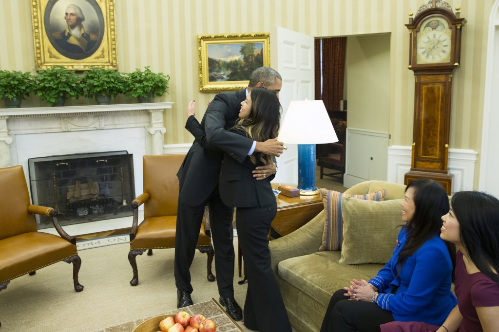 President Barack Obama hugs Ebola survivor Nina Pham in the Oval Office of the White House in Washington, Friday, Oct. 24, 2014. Pham, the first nurse diagnosed with Ebola after treating an infected man at a Dallas hospital is free of the virus. The 26-year-old Pham arrived last week at the NIH Clinical Center. She had been flown there from Texas Health Presbyterian Hospital Dallas. Pham's mother Diana, center, and sister Cathy Pham watch.  (AP Photo/Evan Vucci)