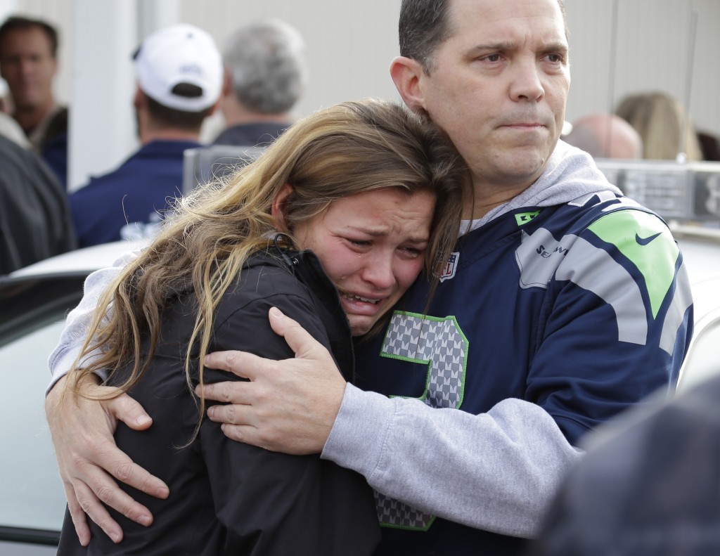 People react as they wait at a church, Friday, Oct. 24, 2014, where students were taken to be reunited with parents following a shooting at Marysville Pilchuck High School in Marysville, Wash. (AP Photo/Ted S. Warren)