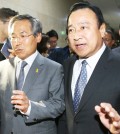 Rep. Lee Wan-koo, right, floor leader of the ruling Saenuri Party, and his counterpart Woo Yoon-keun of the main opposition New Politics Alliance for Democracy walk out of a National Assembly conference room, Friday, after they agreed on three Sewol-related bills. (Yonhap)