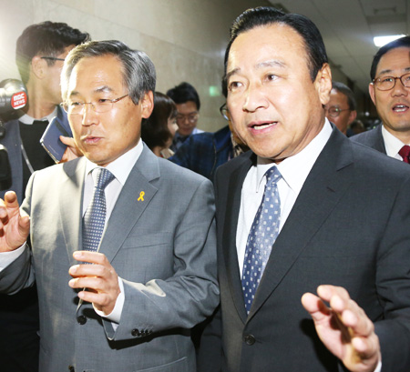 Rep. Lee Wan-koo, right, floor leader of the ruling Saenuri Party, and his counterpart Woo Yoon-keun of the main opposition New Politics Alliance for Democracy walk out of a National Assembly conference room, Friday, after they agreed on three Sewol-related bills. (Yonhap)