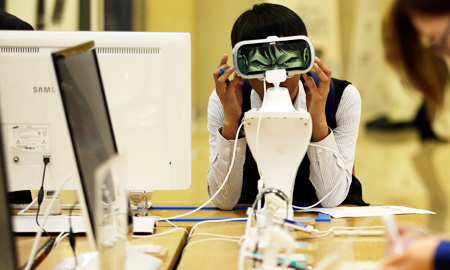A student tries out Samsung Electronics' Gear products at one of the technology giant's shop in Seoul, Thursday. Samsung Electronics has recently vowed to overhaul its handset lineup as its smartphone sales are on the decline amid tougher competition from Apple and Chinese rivals. (AP/Yonhap)