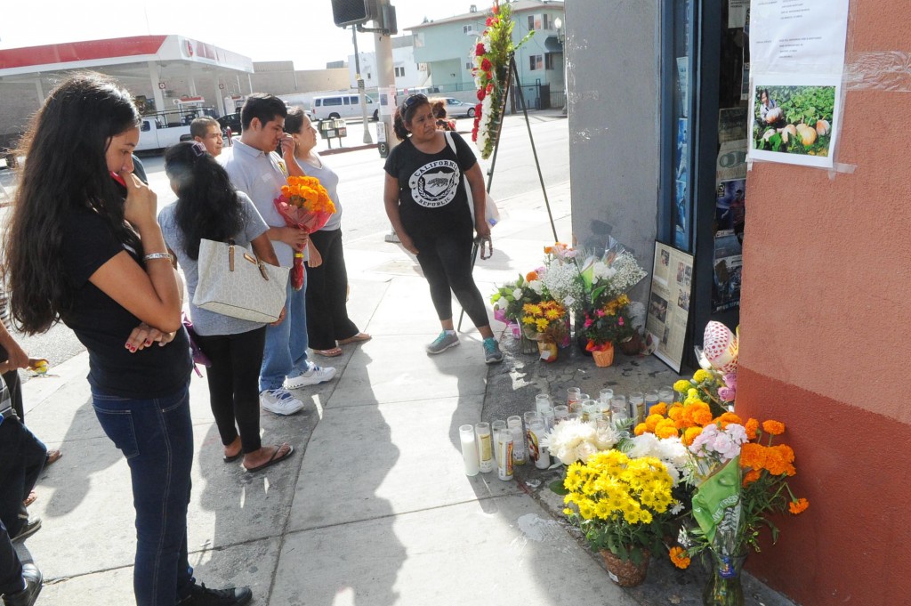 Mourners gather in front of OK Liquor in Los Angeles' Koreatown following Owner Lee Young-ok's death Thursday. (Park Sang-hyuk/The Korea Times)