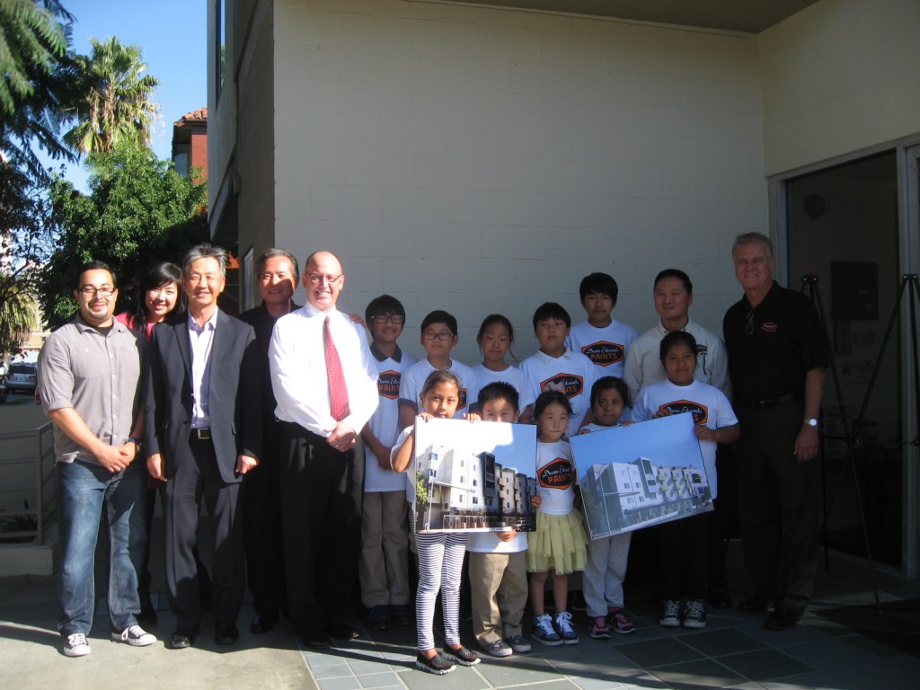 KYCC and Dunn-Edwards Paint Vice President Tim Bosveld, far right, celebrate the completion of a repainting of a low-income apartment in Koreatown Tuesday.