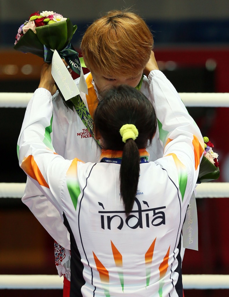 Sarita Devi slips the bronze medal around South Korea’s silver medalist Park Jin-a’s neck. The Korean appeared too stunned to immediately react. (Yonhap)