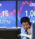 A dealer works in the deal room of the Korea Exchange Bank in Seoul, Thursday, as signboards show the KOSPI ending at 1976.16, the lowest level in 3 months, and the dollar trading at 1,061.40 won. (Yonhap)