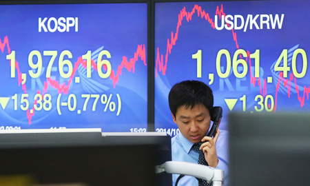 A dealer works in the deal room of the Korea Exchange Bank in Seoul, Thursday, as signboards show the KOSPI ending at 1976.16, the lowest level in 3 months, and the dollar trading at 1,061.40 won. (Yonhap)