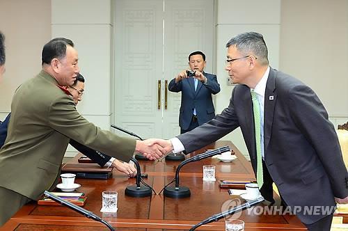 Ryu Je-seung, right, South Korea's Deputy Minister for National Defense Policy, and Kim Yong-chol, who leads North Korea's Reconnaissance General Bureau, shake hands before the military talks at the truce village of Panmunjom on Oct. 15, 2014. (Yonhap)