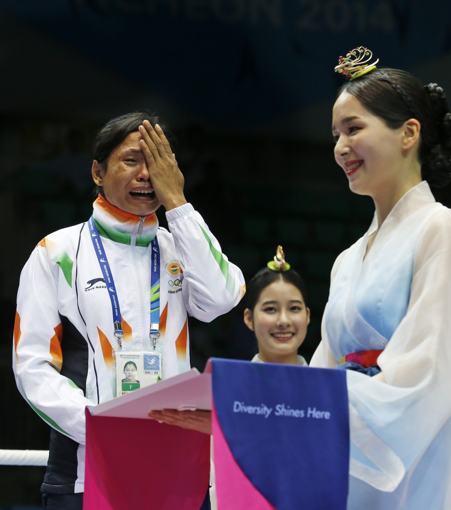 India's L. Sarita Devi cries standing beside bronze medalist Vietnam's Thi Duyen Luu after she refused her bronze medal during the medal ceremony for the women’s light 60-kilogram division boxing at the 17th Asian Games in Incheon, South Korea, Wednesday, Oct. 1, 2014. India's protest against the outcome of an Asian Games boxing semifinal that was awarded to South Korea's Park Ji-na over Devi in the women's 60-kilogram division was rejected on Tuesday. Devi rejected her medal in protest against the result. (AP Photo/Kin Cheung)