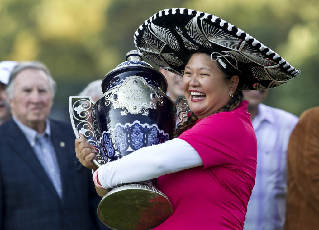 Christina Kim holds her trophy after winning the Lorena Ochoa Invitational LPGA golf tournament in Mexico City, Sunday, Nov. 16, 2014. Kim won the Invitational on Sunday for her first LPGA Tour title in nine years, beating China's Shanshan Feng in a playoff after blowing a five-stroke lead in the final round. (AP Photo/Christian Palma)