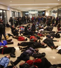 Protestors gather inside of the Westlake Center in Seattle on Friday, Nov. 28, 2014, to protest the Ferguson grand jury decision. More than 200 protesters, some chanting "Black Lives Matter!" tried to disrupt Black Friday shopping and downtown Seattle's traditional Christmas tree lighting ceremony. Police turned out in force, arresting five people, and a downtown mall closed early. (AP Photo/seattlepi.com, Joshua Trujillo)