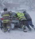 Firefighters from West End Hose Company in Depew, N.Y. help a stuck motorist on Transit Road, Tuesday, Nov. 18, 2014.  Several feet of lake-effect snow paralyzed the Buffalo area Tuesday, forcing state troopers to deliver blankets and other supplies to motorists stranded on the New York State Thruway and adding an ominous note to a wintry season thats already snarling travel and numbing fingers from the Midwest to the Carolinas.  (AP Photo/The Buffalo News, Derek Gee)