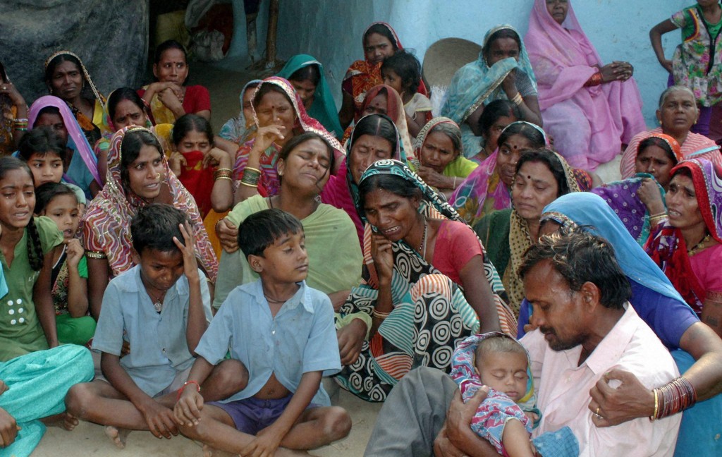 Relatives mourn the death of women who died after undergoing sterilization surgeries, at a village near Bilaspur, in the central Indian state of Chhattisgarh, Tuesday, Nov. 11, 2014. Eight Indian women have died and more than a dozen others in critical condition Tuesday after undergoing sterilization surgeries in a free government-run program to help slow the country's population growth. A total of 83 women, all poor villagers under the age of 32, had the operations Saturday in a hospital outside Bilaspur city. Each of the women had received a payment of 600 rupees, or about $10, to participate in the program, said the state's chief medical officer, Dr. S.K. Mandal. (AP Photo/Press Trust of India)