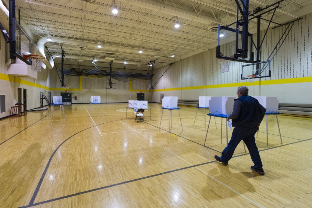 A voter heads to a voting booth with his ballot in hand at Speedway High School, Speedway, Ind., Tuesday, Nov. 4, 2014.  Record-low voter turnout could be the most notable development of the day as California is not faring much better. (AP Photo/Doug McSchooler)